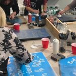 Adults making custom wood signs at a DIY workshop